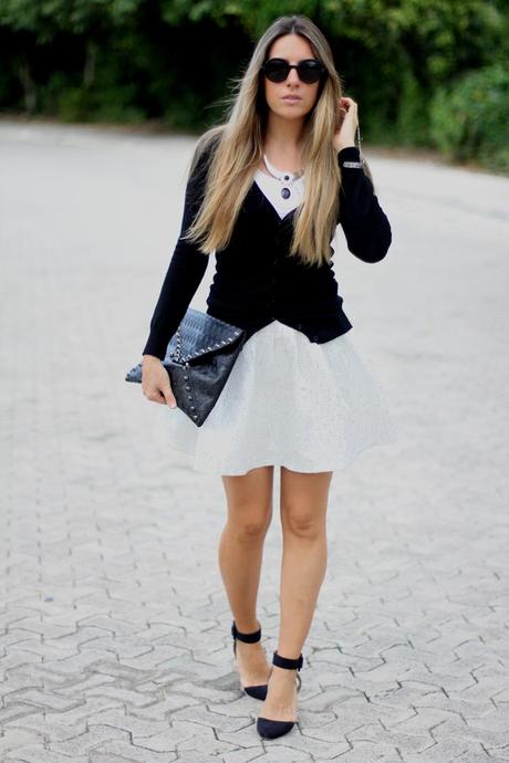Fashion blogger wearing silver skater skirt and studded clutch