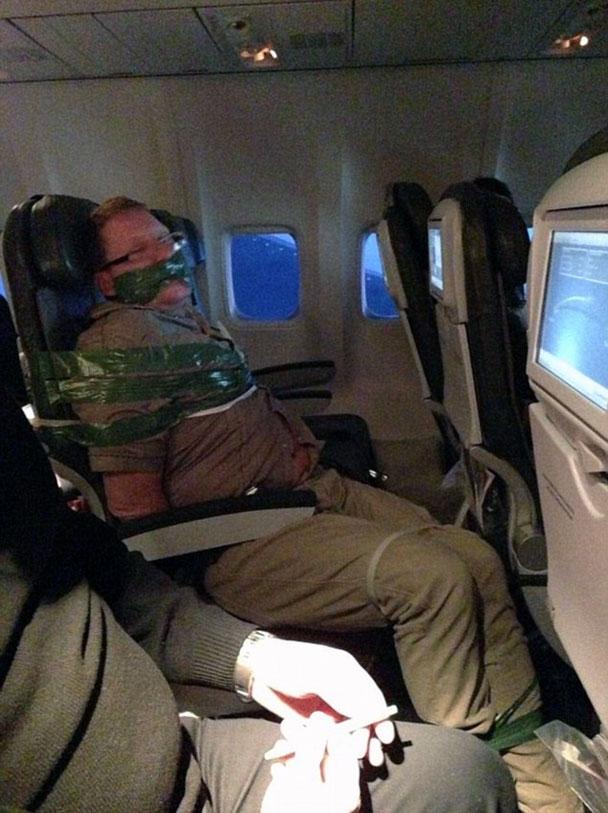 pasajero avión atado con cinta al asiento
