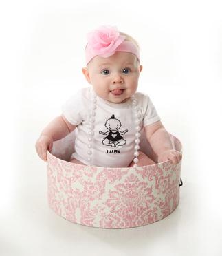 bebé con lazo roza y body dentro de una caja