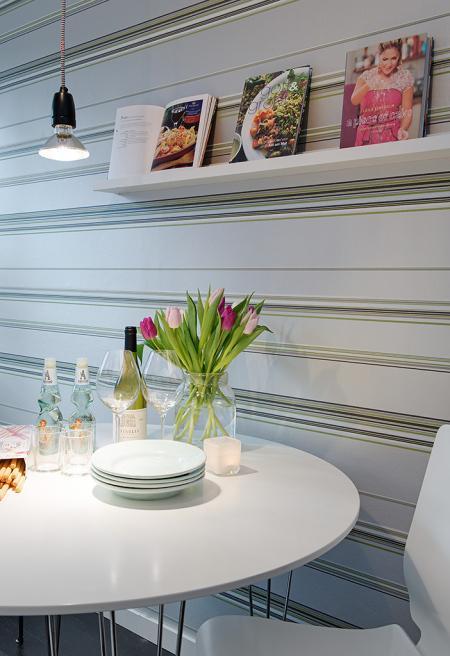 Un piso de 38 m² perfecto para una persona suelo madera negro sofá gris sillas taburetes tolix papel de pared floral papel de pared de rayas muebles de diseño lámpara diseño arco foto dibujo maddonna estilo nórdico escandinavo escalera madera blanca decoración diseño de pisos pequeños diseño de interiores decoración pisos pequeños decoración nórdica decoración en blanco decoración de interiores cocinas modernas cocinas ikea cocinas blancas blog interiorismo blog diseño nordico blog decoración artículos decoración