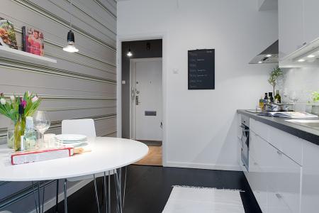Un piso de 38 m² perfecto para una persona suelo madera negro sofá gris sillas taburetes tolix papel de pared floral papel de pared de rayas muebles de diseño lámpara diseño arco foto dibujo maddonna estilo nórdico escandinavo escalera madera blanca decoración diseño de pisos pequeños diseño de interiores decoración pisos pequeños decoración nórdica decoración en blanco decoración de interiores cocinas modernas cocinas ikea cocinas blancas blog interiorismo blog diseño nordico blog decoración artículos decoración