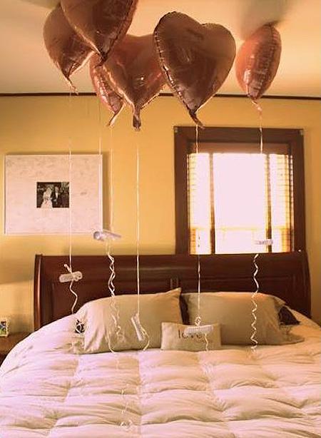 globos con forma de corazón encima de una cama