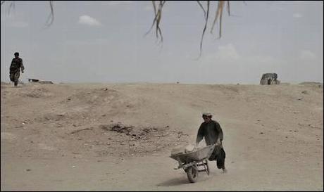 Un chaval afgano transporta una carretilla con ladrillos cerca del
 destacamento de los marines en Marjah.