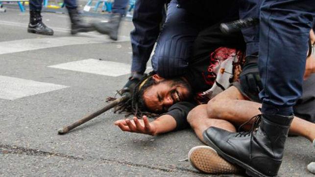 Policías antidisturbios aplastan a un manifestante el 25S. Foto: Fotogracción