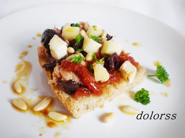 Tostada de pan de avena con queso de cabra, atún y tomates secos