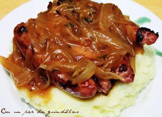 Salchichas con salsa de cebolla y puré de patatas.