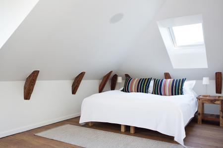 vistas a los tejados de la ciudad vigas de madera en el techo tragaluces accionados por control remoto suelo de madera de roble sistema de aspiración centralizada luces empotradas estilo nórdico atico estilo nórdico electrodomésticos de diseño dormitorio que integra walking closet y cuarto de baño diseño aticos decoración áticos diáfanos blog decoración nórdica Ático de estilo nórdico con chimenea y walking closet 