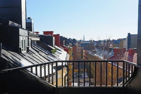 vistas a los tejados de la ciudad vigas de madera en el techo tragaluces accionados por control remoto suelo de madera de roble sistema de aspiración centralizada luces empotradas estilo nórdico atico estilo nórdico electrodomésticos de diseño dormitorio que integra walking closet y cuarto de baño diseño aticos decoración áticos diáfanos blog decoración nórdica Ático de estilo nórdico con chimenea y walking closet 