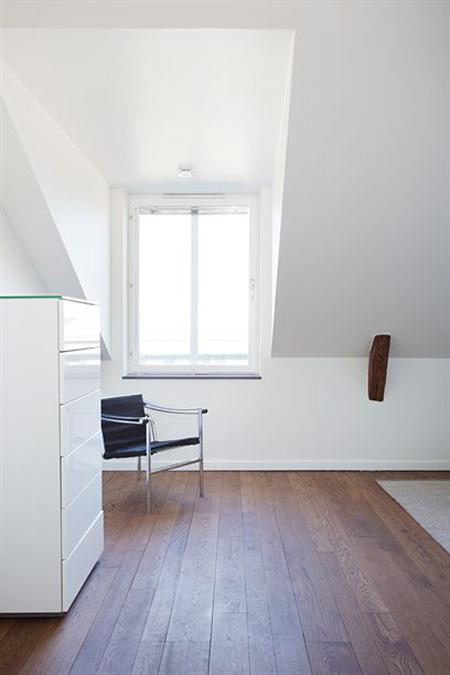 vistas a los tejados de la ciudad vigas de madera en el techo tragaluces accionados por control remoto suelo de madera de roble sistema de aspiración centralizada luces empotradas estilo nórdico atico estilo nórdico electrodomésticos de diseño dormitorio que integra walking closet y cuarto de baño diseño aticos decoración áticos diáfanos blog decoración nórdica Ático de estilo nórdico con chimenea y walking closet 