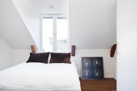 vistas a los tejados de la ciudad vigas de madera en el techo tragaluces accionados por control remoto suelo de madera de roble sistema de aspiración centralizada luces empotradas estilo nórdico atico estilo nórdico electrodomésticos de diseño dormitorio que integra walking closet y cuarto de baño diseño aticos decoración áticos diáfanos blog decoración nórdica Ático de estilo nórdico con chimenea y walking closet 