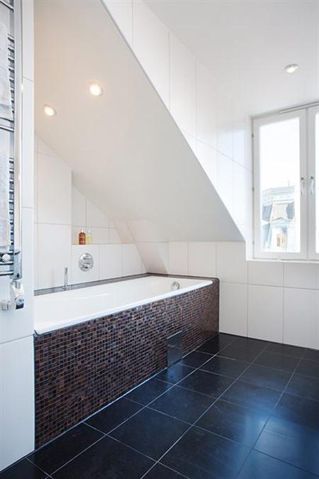 vistas a los tejados de la ciudad vigas de madera en el techo tragaluces accionados por control remoto suelo de madera de roble sistema de aspiración centralizada luces empotradas estilo nórdico atico estilo nórdico electrodomésticos de diseño dormitorio que integra walking closet y cuarto de baño diseño aticos decoración áticos diáfanos blog decoración nórdica Ático de estilo nórdico con chimenea y walking closet 