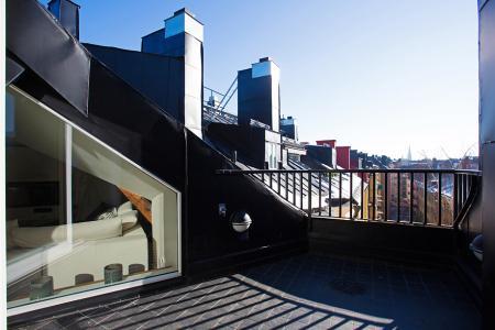 vistas a los tejados de la ciudad vigas de madera en el techo tragaluces accionados por control remoto suelo de madera de roble sistema de aspiración centralizada luces empotradas estilo nórdico atico estilo nórdico electrodomésticos de diseño dormitorio que integra walking closet y cuarto de baño diseño aticos decoración áticos diáfanos blog decoración nórdica Ático de estilo nórdico con chimenea y walking closet 