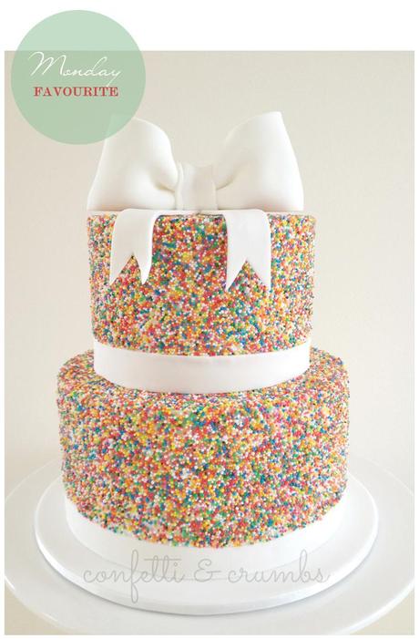 una festiva tarta cubierta con sprinkles y un lazo de fondant