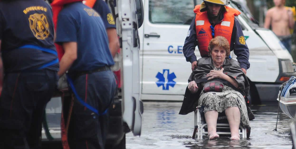 Una mujer es evacuada por un grupo de bomberos este miércoles, en La Plata (Argentina).  EFE/Javier Brusco