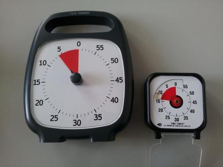 Time Timer Plus junto al Time Timer de bolsillo. Obsérvese, además de la diferencia de tamaño, que tiene una imagen más limpia y uniforme, con menos estímulos distractores.