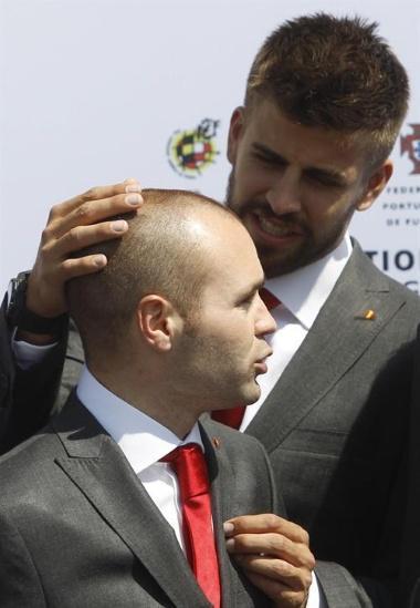 Spain s Gerard Pique(R) and Andres Iniesta talk before posing for a family photo with Spanish Crown Prince Felipe and the rest of Spain's 2010 World Cup squad at the Spanish Soccer Federation headquarters in Las Rozas, outside Madrid, May 24, 2010. REUTERS/Susana Vera (SPAIN - Tags: SPORT SOCCER WORLD CUP)
