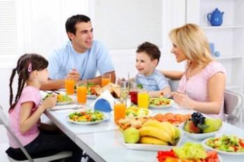 Beneficios de los hábitos alimentarios en el niño Happy family dining at the home.