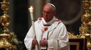 Pope Francis holds a candle as he leads a vigil mass during Easter celebrations at St. Peter's Basilica in the Vatican