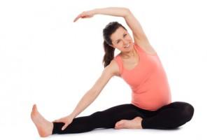 Una mujer embarazada hace ejercicios desde el suelo para mantenerse en forma.