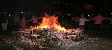Una hoguera en Struga y la gente detrás bailando el baile tradicional
