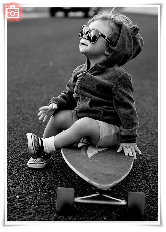 foto del día niño en monopatín con gafas de sol