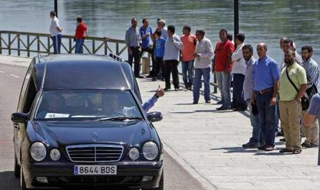 Un furgón fúnebre traslada el cuerpo de uno de los niños ahogados por el paseo fluvial.