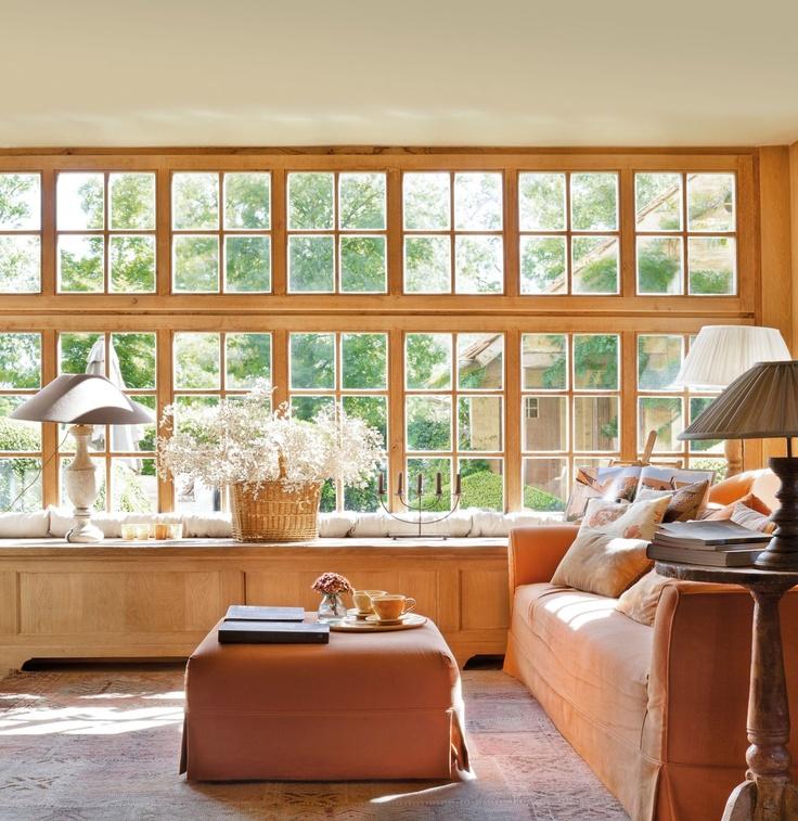 Ventanal de madera con cuarterones y banco a medida