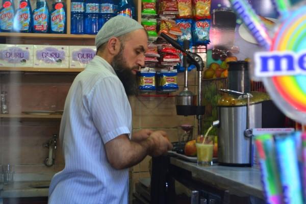 Un vendedor musulmán exprime jugos afuera del Grand Bazaar