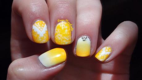 Uñas decoradas con motivos étnicos y tachuelas en amarillo