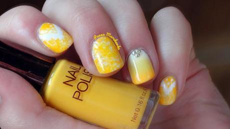 Uñas decoradas con motivos étnicos y tachuelas en amarillo