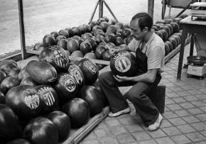 Un frutero talla escudos de equipos de fútbol en unas sandías. Madrid, 1951