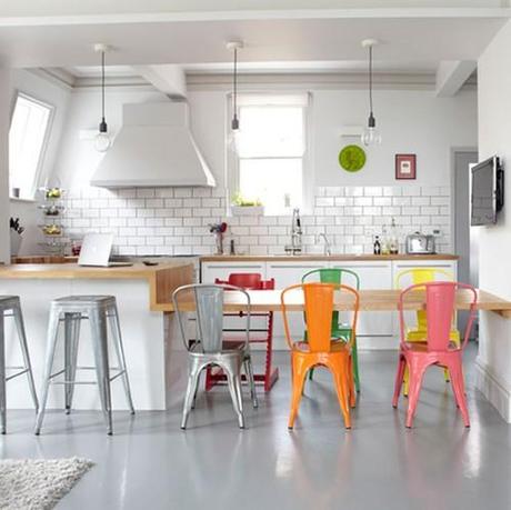 Una cocina con cada silla de un color