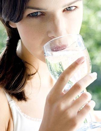 Young woman drinking a glass of mineral water