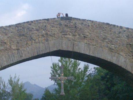 La réplica de la Cruz de la Victoria, símbolo de Asturias, colgada del puente romano de Cangas de Onís