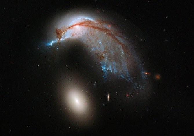 Espectacular distorsión de galaxia espiral por la gravedad de una elíptica cercana