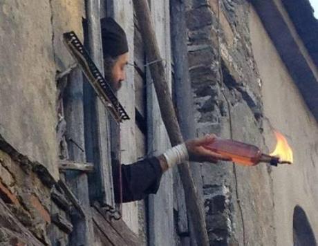 Monje del monasterio de Esfigmenu lanza un cóctel Molotov