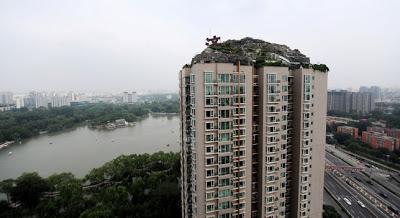 Construye un Hombre Chino un Monte en lo Alto de un Bloque de Pisos