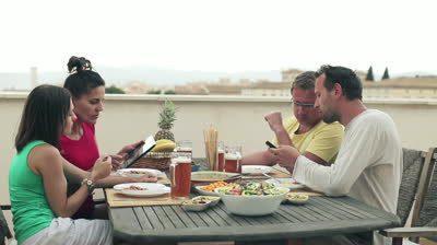 Imagen de http://ak3.picdn.net/shutterstock/videos/2379755/preview/stock-footage-four-friends-with-tablet-and-smartphone-by-the-table-full-of-food.jpg