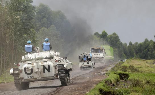 U.N. peacekeepers drive tank as they patrol past deserted Kibati village