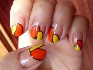 Manicura naranja y amarillo, borde negro.