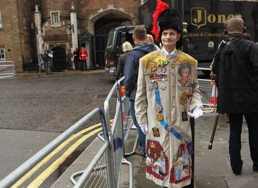 Fan Royal William Willis fuera de las puertas del palacio de St James en Londres esperando el inicio del bautizo del príncipe Jorge de Cambridge.