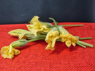 Flores de calabacín en tempura, rellenas de atún y queso con salsa pesto de frutos secos.