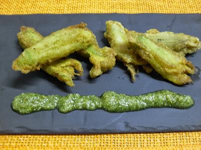 Flores de calabacín en tempura, rellenas de atún y queso con salsa pesto de frutos secos.