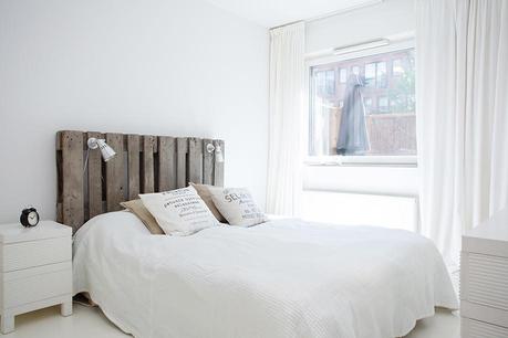 white bedroom. Rustic wooden headboard.