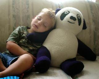 niño pequeño dormido con oso panda