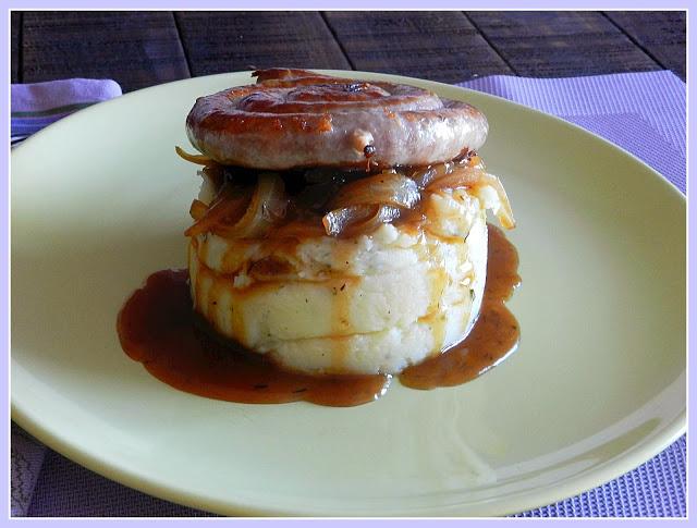 Piruleta de salchicha de ternera sobre timbal de patata y cebolla caramelizada