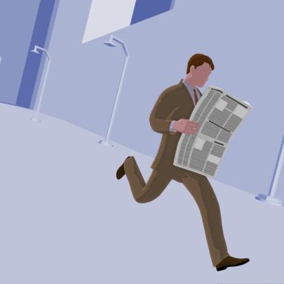 Businessman holding a newspaper and running