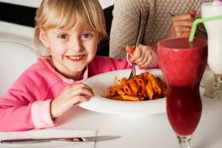 Niña comiendo macarrones