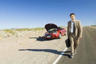 Businessman with car trouble in desert
