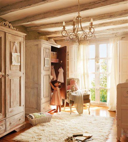 Dormitorio en tonos beige con dos armarios, butaca, lámpara de lágrimas y niña